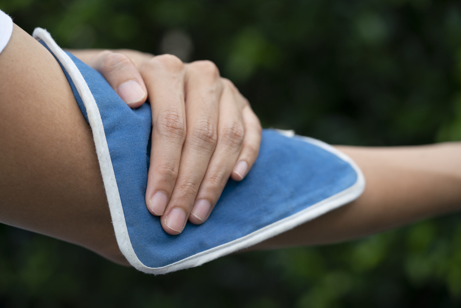 woman putting an ice pack on her elbow pain, healthy and medical concept
