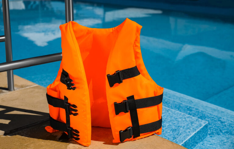 Bright orange life jacket near swimming pool